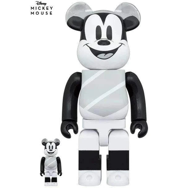 Bearbrick sæt featuring Mickey Mouse in hat and poncho, based on The Gallopin' Gaucho 1928 design, black and white figures, 400% and 100% sizes.