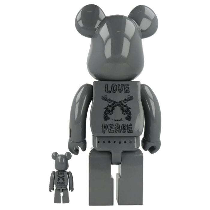 400% and 100% gray Bearbrick figures with crossed pistols and "Love Peace" text from Roarguns and Medicom Toy collaboration.